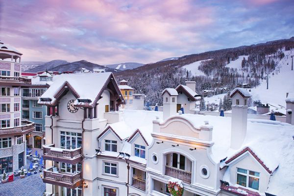 The Arrabelle at Vail Square, A RockResort view of the main building, surrounded by snowy mountains 