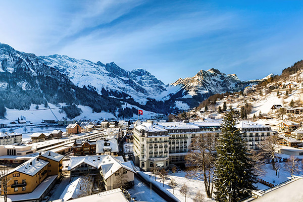 Kempinski Palace Engelberg hotel square surrounded by snow, mountains in the background